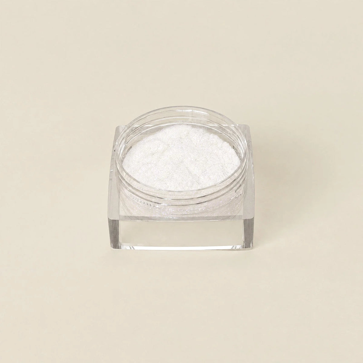 Een helder vierkant glazen potje gevuld met fijn wit poeder uit de chrome powder bundle 5 kleuren