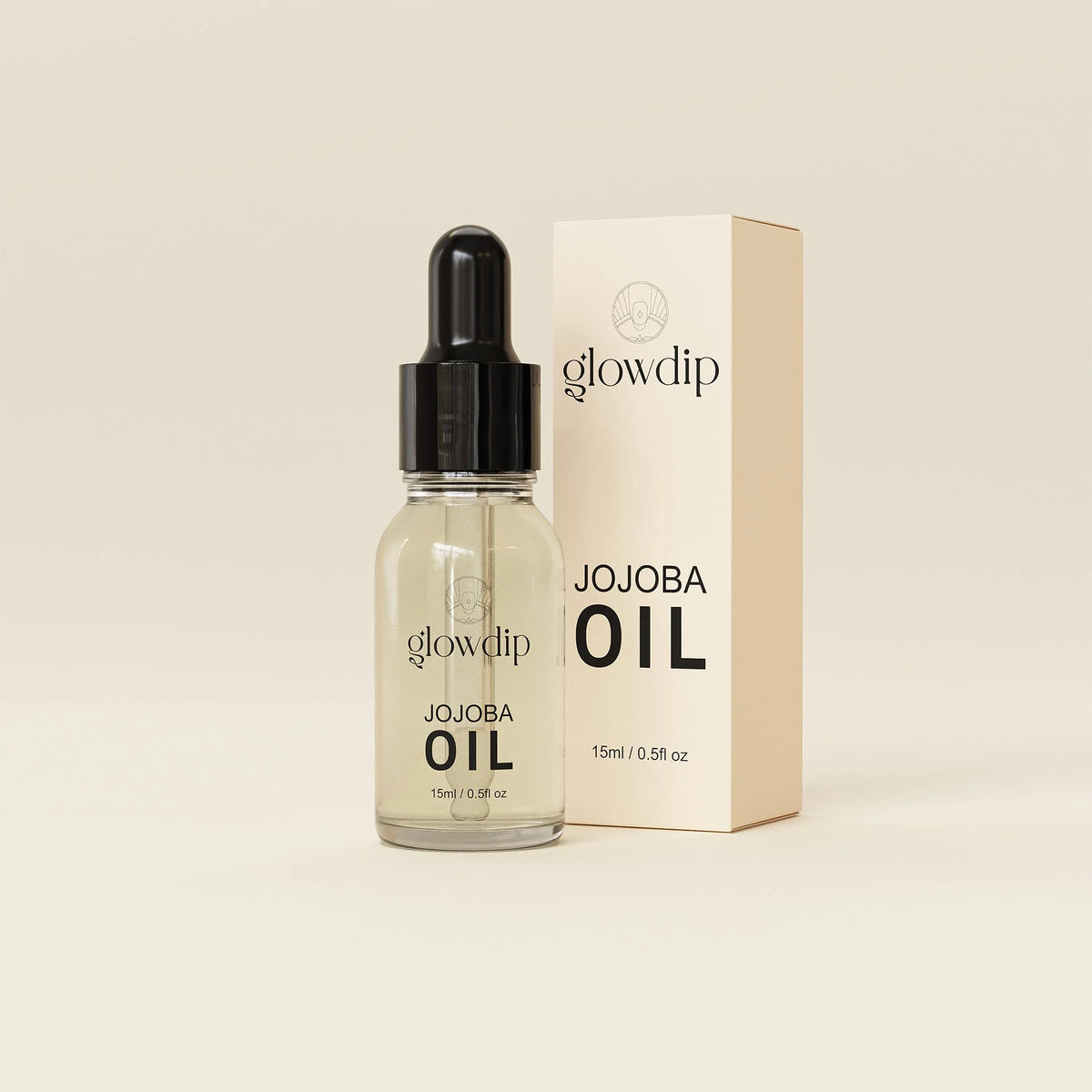 Een heldere glazen fles glowdip jojoba nagelriemolie met zwarte pipetdop en beige minimalistische verpakking